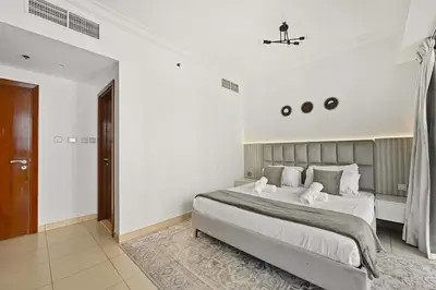 a bedroom with a large bed in a white room at Incredible downtown location in Dubai