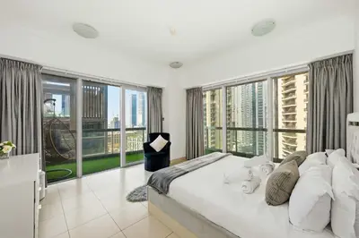 a bedroom with a large bed and large windows at Incredible downtown location in Dubai