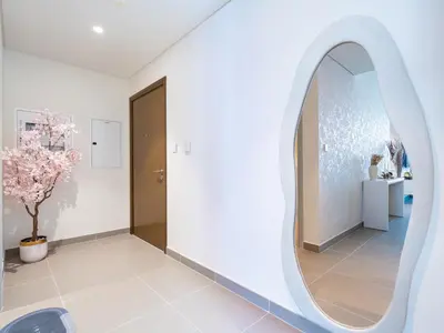 a hallway with a round mirror on the wall at Burj Khalifa Bliss I 4 bedroom Apartments I Burj Khalifa & Fountain Views I Free Gym, Pool, Parking, Wi-Fi and PS5 I by Skyline Serenity in Dubai