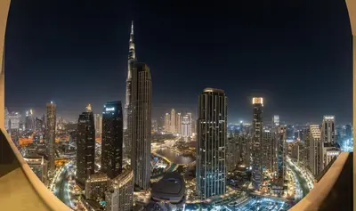 a view of a large city at night at Burj Khalifa Bliss I 4 bedroom Apartments I Burj Khalifa & Fountain Views I Free Gym, Pool, Parking, Wi-Fi and PS5 I by Skyline Serenity in Dubai