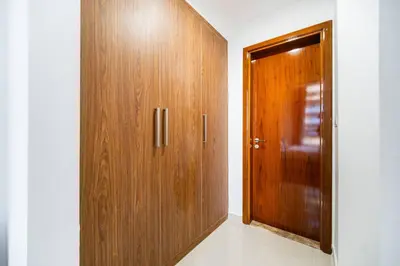 a wooden door in a room with a hallway at Elegant Escapes - Homely 1B in Dunya Tower in Dubai