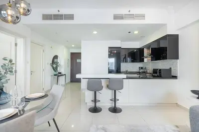 a white kitchen with a glass table and chairs at New Listing & Burj Khalifa View & Dubai Mall in Dubai