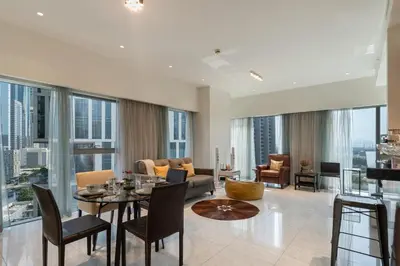 a living room with a couch and a table and chairs at Easy access to Metro - 1BR in Central Park, DIFC - Allsopp&Allsopp in Dubai