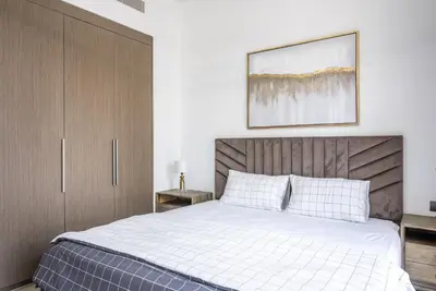 a bedroom with a bed and a picture on the wall at Apartment in Downtown Dubai in ACT I ACT II - 5 min walk to Dubai Mall in Dubai