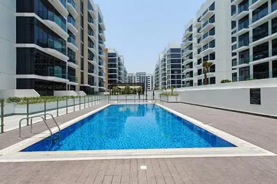 a swimming pool in front of two tall buildings at Pool View & 2 adults 2 kids & Brand New & Czechin in Dubai