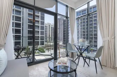 a living room with a table and chairs and a large window at Pool View & 2 adults 2 kids & Brand New & Czechin in Dubai