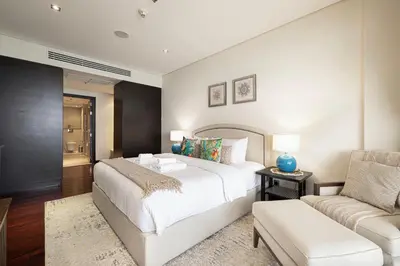 a bedroom with a white bed and a couch at Beachfront Residences with Full Sea and Burj AlArab Views in Luxury Resort in Dubai