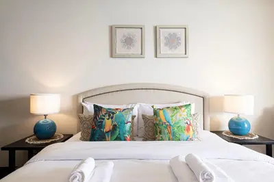a bedroom with a white bed with two lamps at Beachfront Residences with Full Sea and Burj AlArab Views in Luxury Resort in Dubai