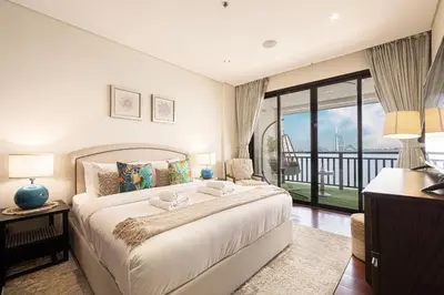 a bedroom with a large bed and a balcony at Beachfront Residences with Full Sea and Burj AlArab Views in Luxury Resort in Dubai