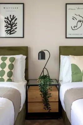 a bedroom with two beds and a table with a plant on it at Frank Porter - Downtown Views II Tower 1 in Dubai