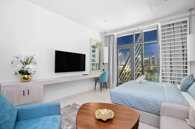 a living room with a couch and a tv at Goldbest - Seven Palm 4ppl in Dubai