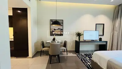 a bedroom with a bed and a table and a desk at Modern loft Studio in Damac Majestine,Business Bay in Dubai