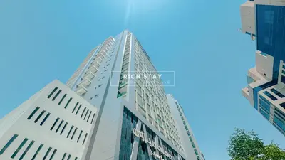 a tall white building against a blue sky at Modern loft Studio in Damac Majestine,Business Bay in Dubai