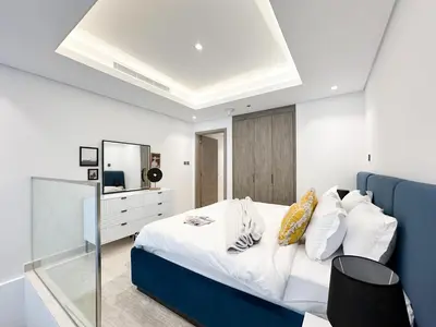 a bedroom with a large bed with a blue headboard at Trophy - Elevated Living in Luxurious Business Bay Loft in Dubai