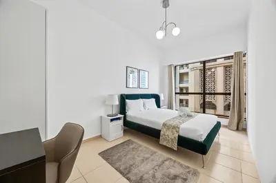a bedroom with a bed and a desk and a window at Prime Spacious 5 Plus 1 BR Apt On JBR Beach near Metro ,Walk to The Mall, Dining & Entertainment - By Sunkissed Holiday Homes in Dubai