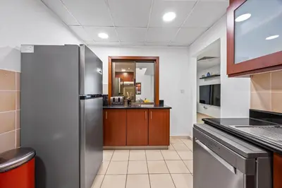 a kitchen with a stainless steel refrigerator and a counter at Prime Spacious 5 Plus 1 BR Apt On JBR Beach near Metro ,Walk to The Mall, Dining & Entertainment - By Sunkissed Holiday Homes in Dubai
