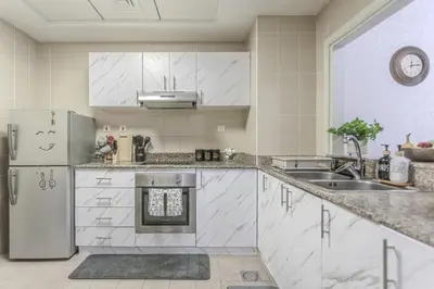 a white kitchen with a sink and a refrigerator at Stunning 1 Bedroom Apartment in Dubai Marina in Dubai