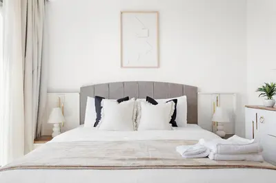 a white bedroom with a large bed with white pillows at Silkhaus High Floor Luxury 1 BDR with Stunning View in Dubai