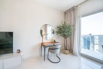 a dressing table and mirror in a room with a window at Stunning High Floor Studio Apartment in BusinessBay in Dubai