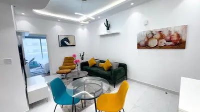 a living room with a green couch and chairs at Dubai Marina - 1BHK Modish Apartment in Dubai