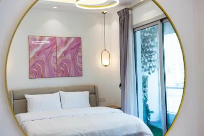 a mirror reflecting a bedroom with a bed and a window at Dubai Marina - 1BHK Modish Apartment in Dubai