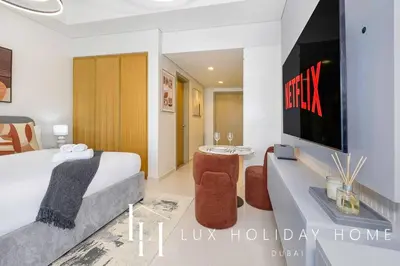 a hotel room with a bed and a tv at LUX The Aykon Suite in Dubai