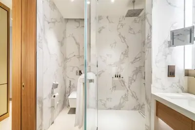 a white bathroom with a shower and a sink at Dream Inn - Address Dubai Opera Residences in Dubai