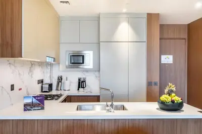 a kitchen with a sink and a bowl of fruit on a counter at Dream Inn - Address Dubai Opera Residences in Dubai