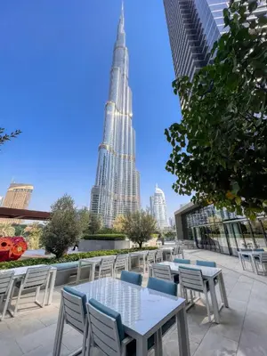 a patio with tables and chairs in front of the shard at Dream Inn - Address Dubai Opera Residences in Dubai