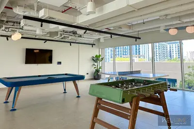 two ping pong tables in a room with windows at WelHome - Fancy 1BR Apt at Dubai Hills near Dubai Hills Mall in Dubai