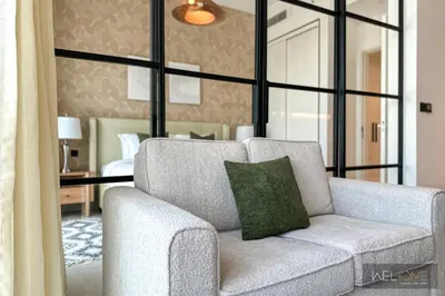a living room with a chair and a mirror at WelHome - Fancy 1BR Apt at Dubai Hills near Dubai Hills Mall in Dubai