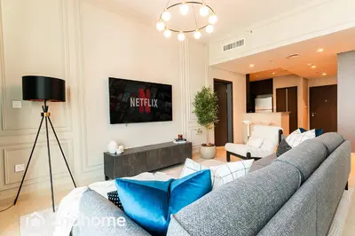 a living room with a gray couch and blue pillows at 2ndHome - Downtown Views 1 in Dubai