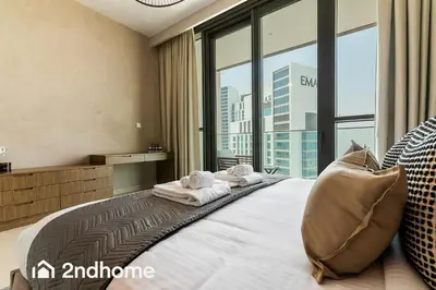 a bedroom with a large bed with a large window at 2ndHome - Downtown Views 1 in Dubai