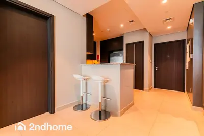 a kitchen with two stools at a counter at 2ndHome - Downtown Views 1 in Dubai