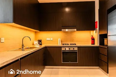 a kitchen with black cabinets and a sink at 2ndHome - Downtown Views 1 in Dubai