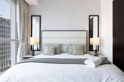 a bedroom with a large white bed with two lamps at Luxury 1-BR with Lake View in Business Bay in Dubai