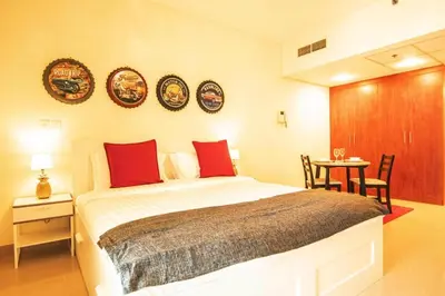 a bedroom with a bed and a table with chairs at Cozy Studio Apartment in DIFC in Dubai