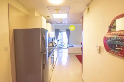 a kitchen with a stainless steel refrigerator in a room at Cozy Studio Apartment in DIFC in Dubai