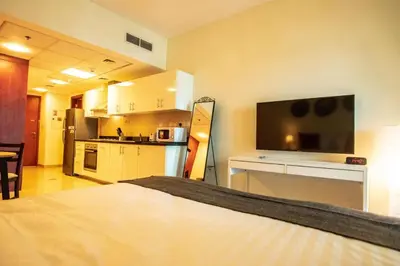 a room with a kitchen and a bed in a room at Cozy Studio Apartment in DIFC in Dubai