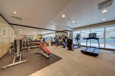a gym with several treadmills and elliptical machines at Canal View l Hotel Studio l Great Amenities in Dubai