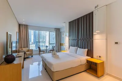 a hotel room with a bed and a living room at Canal View l Hotel Studio l Great Amenities in Dubai
