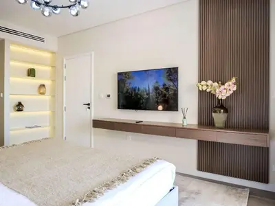 a bedroom with a bed and a tv on a wall at Renovated 1BR Haven in 5 Star Resort in Dubai