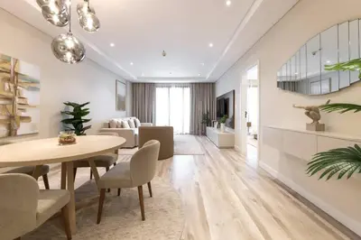 a living room with a table and chairs and a couch at Elegantly Renovated 1BR Apartment at 5 Star Resort in Dubai