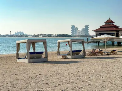 two beach chairs and umbrellas on a beach at Elegantly Renovated 1BR Apartment at 5 Star Resort in Dubai
