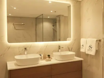 a bathroom with two sinks and a large mirror at Stunning Renovated 1BR Apartment at 5 Star Resort in Dubai