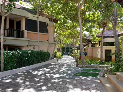 a walkway in front of a building with trees at Stunning Renovated 1BR Apartment at 5 Star Resort in Dubai