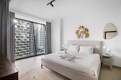 a white bedroom with a large bed and a large window at Iconic Burj View 1BR in Burj Vista Tower Near Shops & Metro in Dubai