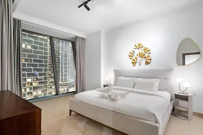 a white bedroom with a large bed and a large window at Iconic Burj View 1BR in Burj Vista Tower Near Shops & Metro in Dubai