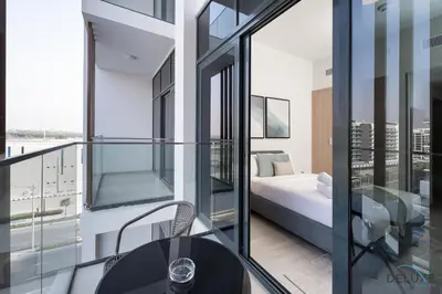 a balcony with a table and a bed in a room at Inviting Studio Apartment at Azizi Riviera 36 in Al Merkadh by Deluxe Holiday Homes in Dubai