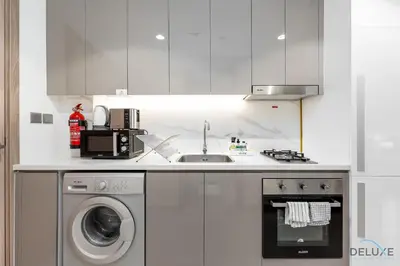 a kitchen with a sink and a washing machine at Inviting Studio Apartment at Azizi Riviera 36 in Al Merkadh by Deluxe Holiday Homes in Dubai